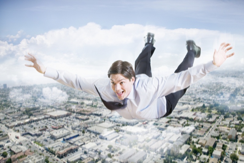 Excited Businessman Flying In The Clouds
